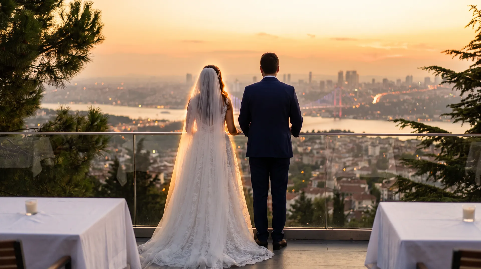 Gelin ve damat terasın kenarında gün batımını izliyor